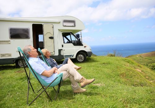 A couple relaxing in folding camping chairs