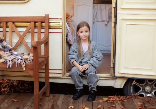 A cute young girl sitting near the trailer door