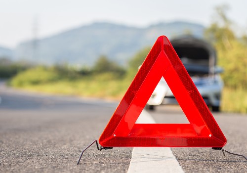 A red warning triangle with a broken-down RV
