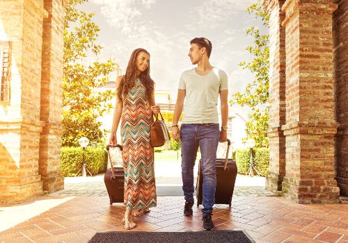 Young couple standing at hotel corridor upon arrival